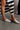 Front view of model holding the Sunrise Macrame Mule in Natural which feature natural crochet knit fabric, slide on style and 1 inch block heel