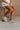 Side view of female model wearing the Alta Sneaker in Off White which features light grey and white suede upper fabric, white sole, and lace up details
