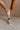 Front view of female model wearing the Alta Sneaker in Off White which features light grey and white suede upper fabric, white sole, and lace up details
