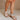 Front side view of female model wearing the Sofft Camille Sandal in Tapioca Grey which features light grey upper fabric, Side zipper with matching leather pull, cross straps and stacked block heel