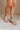 Front side view of female model wearing the Sofft Camille Sandal in Tapioca Grey which features light grey upper fabric, Side zipper with matching leather pull, cross straps and stacked block heel
