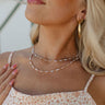 Model is shown in a close-up wearing the Magdelene Necklace in white. 