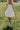 Front view of female model wearing the Rosemary White Bubble Hem Mini Dress that has white fabric, a bubble hem, and thin straps.