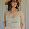 front view of female model wearing the Elsie Stripe V-Neckline Tank which features Stripe Lightweight Fabric, V-Neckline, Cropped Waist, Thick Hem and Sleeveless. the tank is available in black, olive and rust.