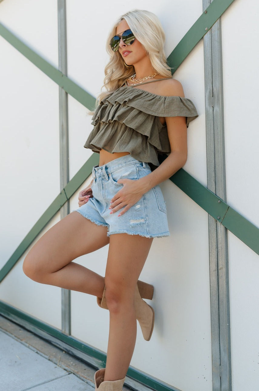 Full body view of female model wearing the Kamila Olive Ruffle Off-The-Shoulder Top which features Olive Green Cotton Fabric, Ruffle Tiered Body, Adjustable Straps and Cropped Waist