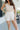 Front view of female model wearing the Ivy White Drawstring Tie Shorts which features White Lightweight Fabric, Pockets On Each Side, Elastic Waistband and Drawstring Tie