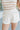 Front view of female model wearing the Ivy White Drawstring Tie Shorts which features White Lightweight Fabric, Pockets On Each Side, Elastic Waistband and Drawstring Tie