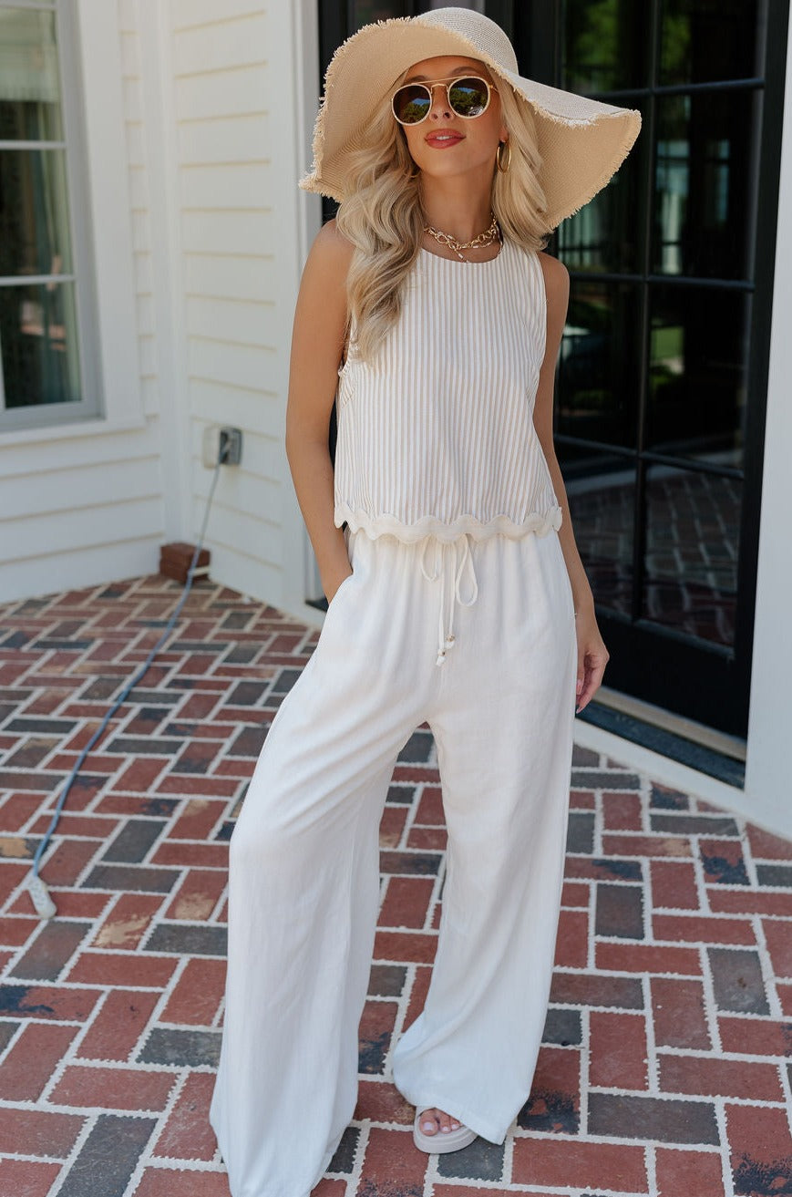 Full body view of female model wearing the Alice Off White Wide Leg Drawstring Pants which features Off White Lightweight Linen Fabric, Off White Lining, Wide Pant Legs, Side Pockets and Elastic Waistband with Drawstring Tie