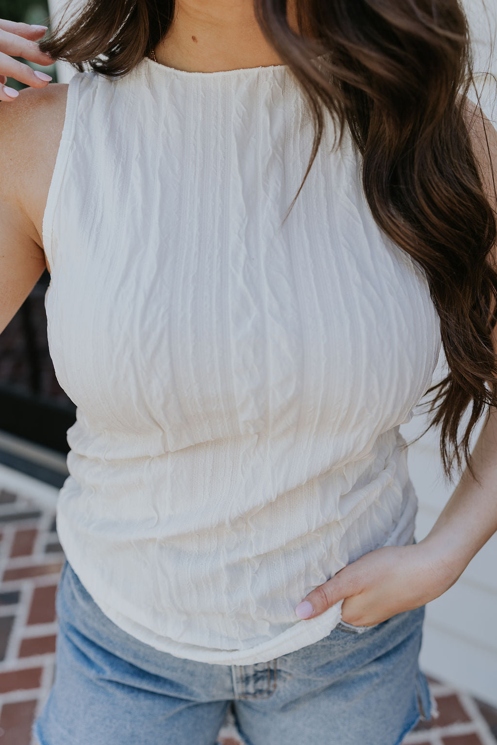 Close up view of female model wearing the Clara Cream Textured Sleeveless Tank which features Cream Texture Fabric, Round Neckline and Sleeveless