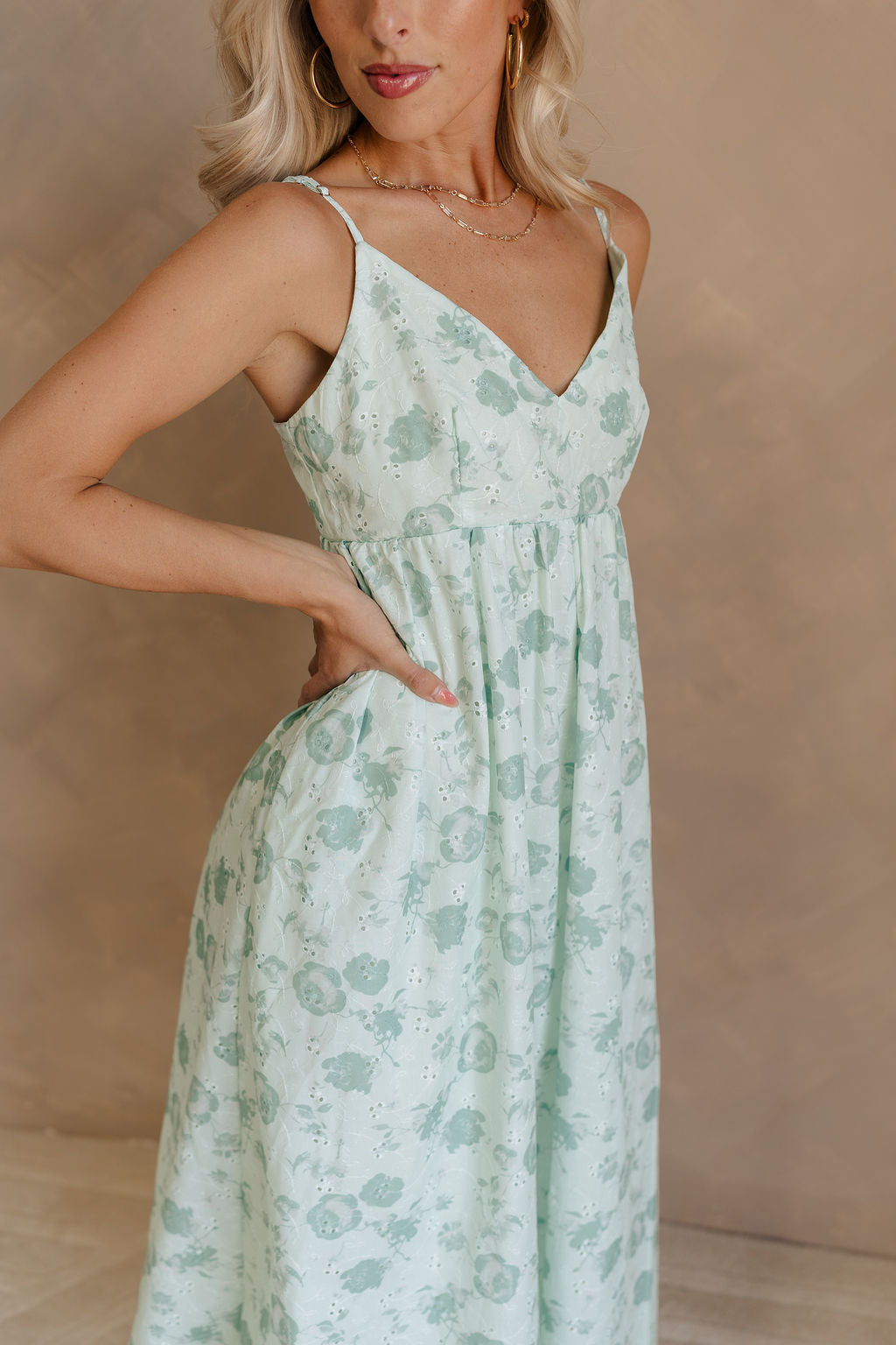 Side view of female model wearing the Kira Mint Green Floral Midi Dress which features Mint green fabric, Green floral print, Floral eyelet embroidery, V-neckline, Adjustable straps and Green lining