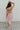 Full body back view of female model wearing the Maya Pink Multi Floral Ruffle Slit Midi Dress which features Pink Multi Floral Sheer Fabric, Light Pink Lining, Ruffle Tier Details, Side Slit Detail, Sweetheart Neckline, Adjustable Straps and Side Zipper with Hook Closure