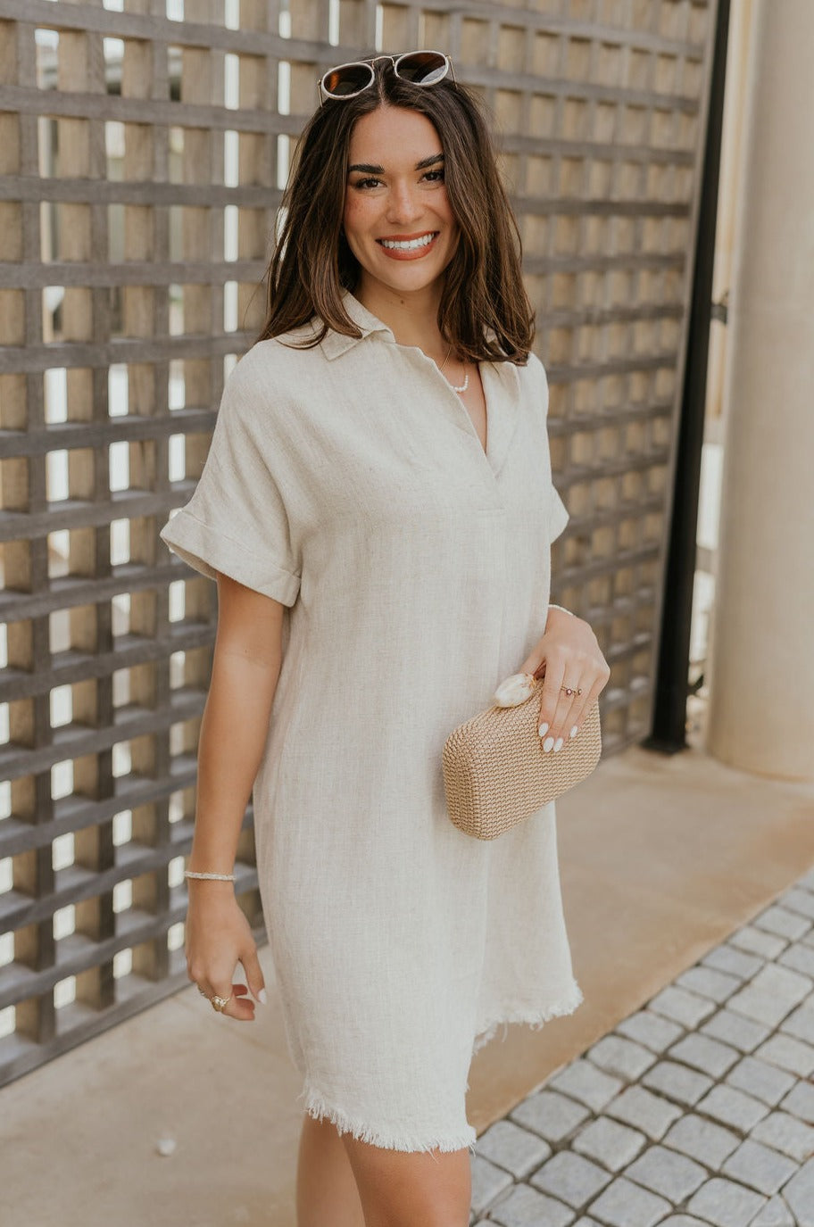 Frontal side view of female model wearing the Juliette Linen Fray Mini Dress which features Linen Lightweight Fabric, Fray Hem Details, V-Neckline with a Collar and Folded Short Sleeves