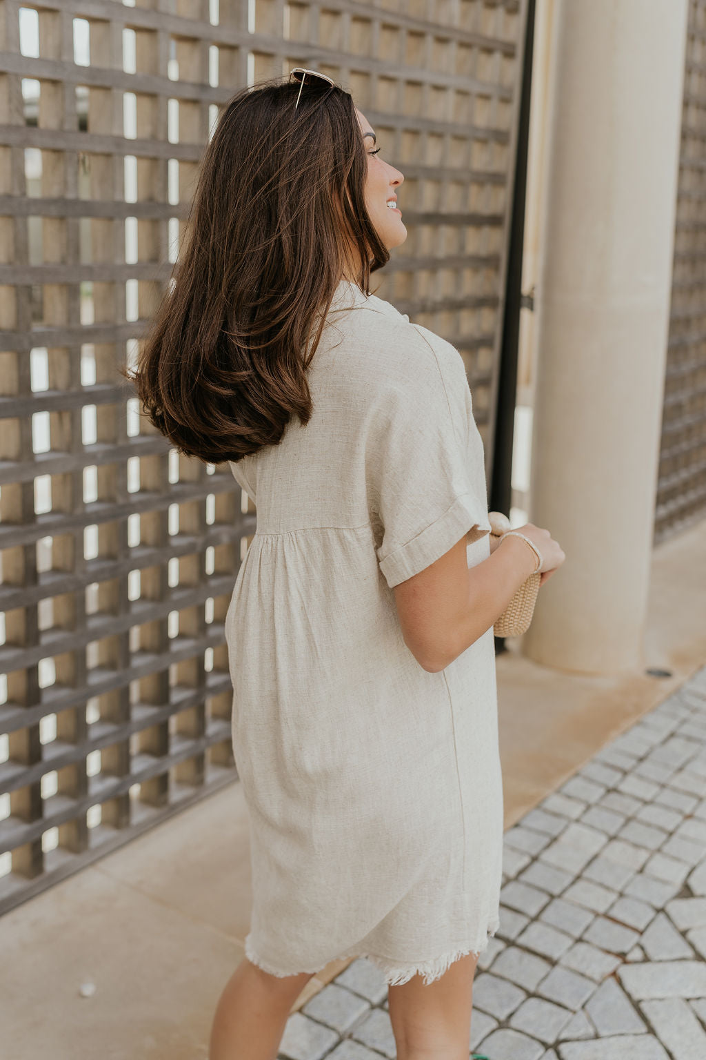 Back side view of female model wearing the Juliette Linen Fray Mini Dress which features Linen Lightweight Fabric, Fray Hem Details, V-Neckline with a Collar and Folded Short Sleeves