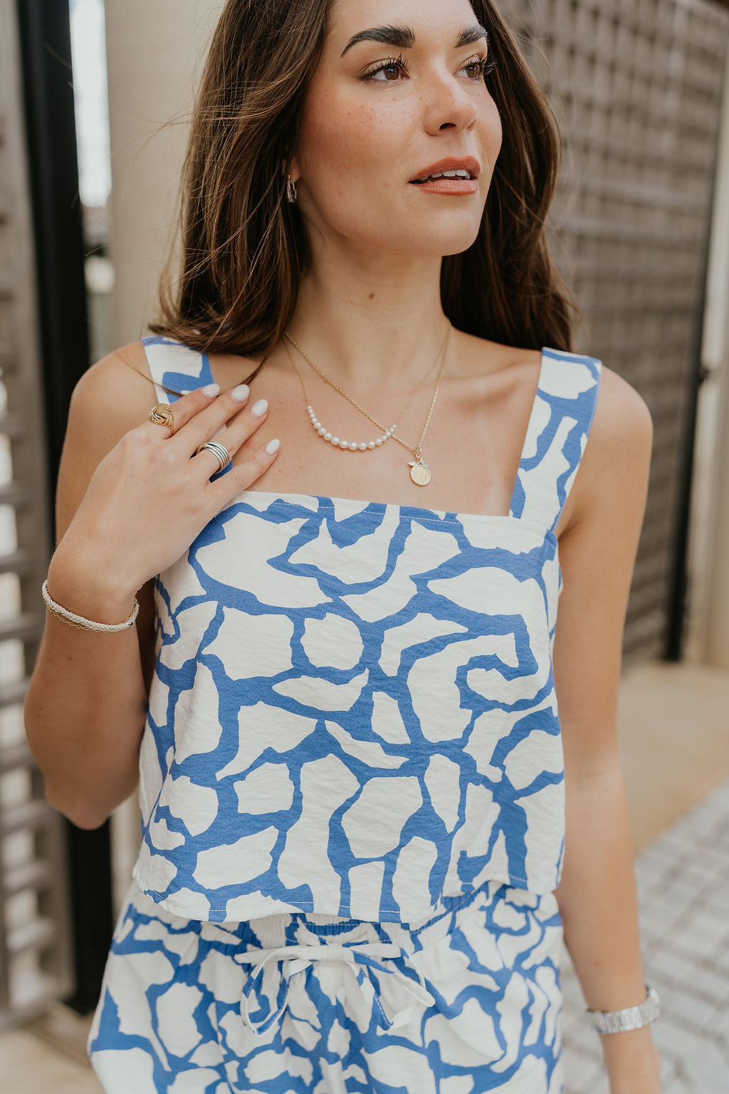 Close up view of female model wearing the Lainey Blue & White Cropped Tank which features Blue and White Lightweight Fabric, White Lining, Monochrome side zipper with hook closure, Square Neckline and Thick Straps