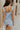 Back view of female model wearing the Lainey Blue & White Cropped Tank which features Blue and White Lightweight Fabric, White Lining, Monochrome side zipper with hook closure, Square Neckline and Thick Straps