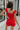 Back view of female model wearing the Rosalie Red Sleeveless Romper which features Tomato Red Lightweight Fabric, Ruffle Hem, Elastic Waistband, Square Neckline and Thick Straps with Tie Details