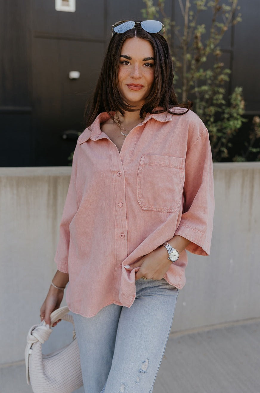 Front view of female model wearing the Ezra Soft Pink Button-Up Top which features Muted Pink Cotton Fabric, Monochrome Front Button Up Closure, Front Left Chest Pocket, Collared Neckline and Short Sleeves
