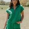Front view of female model wearing the Paulina Green Quilted Quarter Zip-Up Top which features Kelly Green Knit Cotton Fabric, Monochrome Quilt Pattern Detail, Ribbed Hem, Slight Crop Waist, Quarter Zip-Up and Sleeveless