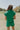 Back view of female model wearing the Paulina Green Quilted Shorts that have green quilted fabric, a drawstring elastic waist, and side pockets. Worn with matching top