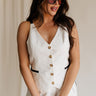 front view of female model wearing the Amelia Off White & Black Button-Up Vest which features White Linen Fabric, Black Trim Details, Front Pockets, Brown Tortoise Button Up, V-Neckline and Sleeveless