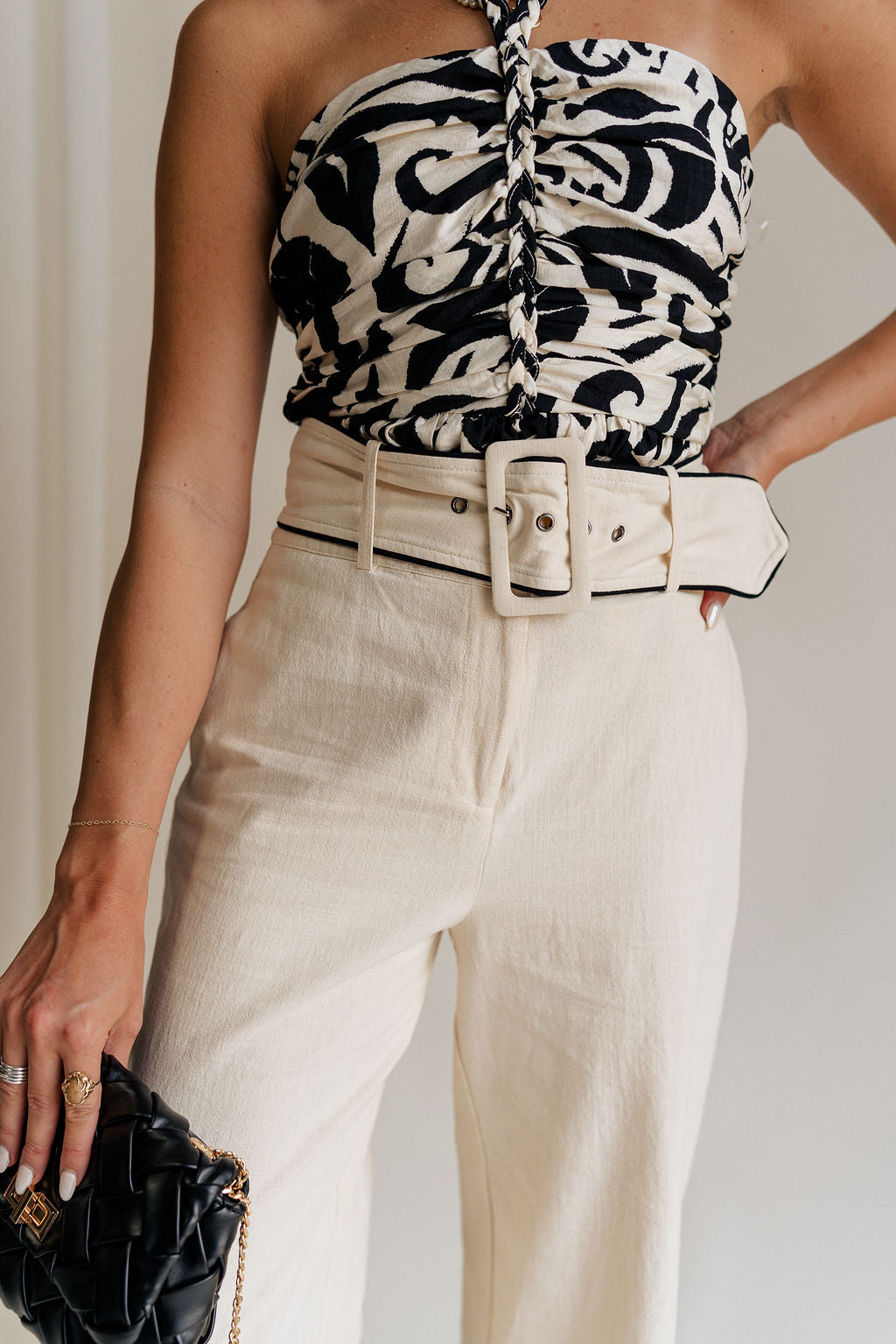 close up view of female model wearing the Luna Natural & Black Belt Wide Leg Pants which features Cream Linen Fabric with Black Details, Side Pockets, Back Pockets, Wide Leg Pants, Monochrome Adjustable Buckle and Front Zipper with Hook Closure