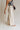 \side view of female model wearing the Luna Natural & Black Belt Wide Leg Pants which features Cream Linen Fabric with Black Details, Side Pockets, Back Pockets, Wide Leg Pants, Monochrome Adjustable Buckle and Front Zipper with Hook Closure