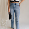 Front view of female model wearing the Eliana Medium Wash Straight Leg Jeans which features Medium Wash Denim Fabric, Straight Leg, High Waist, Two Front Pockets, Two Back Pockets, Front Zipper with Button Closure and Belt Loops