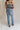 back view of female model wearing the Eliana Medium Wash Straight Leg Jeans which features Medium Wash Denim Fabric, Straight Leg, High Waist, Two Front Pockets, Two Back Pockets, Front Zipper with Button Closure and Belt Loops