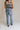 back view of female model wearing the Eliana Medium Wash Straight Leg Jeans which features Medium Wash Denim Fabric, Straight Leg, High Waist, Two Front Pockets, Two Back Pockets, Front Zipper with Button Closure and Belt Loops