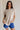 Front view of female model wearing the Arana Knit Short Sleeve Top which features Lightweight Knit Fabric, Slight Slit Details, Front Left Chest Pocket, Round Neckline and Short Sleeves. the top is available in beige and mauve