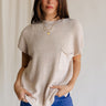 Front view of female model wearing the Arana Knit Short Sleeve Top which features Lightweight Knit Fabric, Slight Slit Details, Front Left Chest Pocket, Round Neckline and Short Sleeves. the top is available in beige and mauve