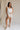 Full body front view of female model wearing the Monroe Off White Satin Tank Top that has off white satin fabric and a v-neckline.