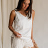 Front view of female model wearing the Monroe Off White Satin Tank Top that has off white satin fabric and a v-neckline.