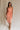 Full body front view of female model wearing the Reyna Peach Ruffle Strapless Midi Dress, that has peach fabric, a strapless neck, a ruffle detail, and midi length hem.