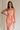 Upper body front view of female model wearing the Reyna Peach Ruffle Strapless Midi Dress, that has peach fabric, a strapless neck, a ruffle detail, and midi length hem.