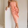 Full body front view of female model wearing the Reyna Peach Ruffle Strapless Midi Dress, that has peach fabric, a strapless neck, a ruffle detail, and midi length hem.