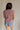 back view of female model wearing the Arana Knit Short Sleeve Top which features Lightweight Knit Fabric, Slight Slit Details, Front Left Chest Pocket, Round Neckline and Short Sleeves. the top is available in beige and mauve
