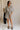 Full body view of female model wearing the Eden Black & Cream Stripe Tie Romper which features Black and Cream Stripe Lightweight Fabric, Mini Length, Side Pockets, Front Button Up Closure, Collared Neckline, Short Sleeves and Waistband Tie Straps