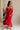 Full body view of female model wearing the Sarah Red Ruffle Hem Midi Dress which features Red Lightweight Fabric, Flare Hem Skirt, Midi Length, Red Lining, Ruched Upper, Strapless and Smocked Back