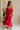 Full body view of female model wearing the Sarah Red Ruffle Hem Midi Dress which features Red Lightweight Fabric, Flare Hem Skirt, Midi Length, Red Lining, Ruched Upper, Strapless and Smocked Back