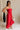 Full body side view of female model wearing the Sarah Red Ruffle Hem Midi Dress which features Red Lightweight Fabric, Flare Hem Skirt, Midi Length, Red Lining, Ruched Upper, Strapless and Smocked Back