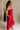 Full body side view of female model wearing the Sarah Red Ruffle Hem Midi Dress which features Red Lightweight Fabric, Flare Hem Skirt, Midi Length, Red Lining, Ruched Upper, Strapless and Smocked Back