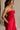 side view of female model wearing the Sarah Red Ruffle Hem Midi Dress which features Red Lightweight Fabric, Flare Hem Skirt, Midi Length, Red Lining, Ruched Upper, Strapless and Smocked Back