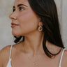 A model is shown from the side wearing the Barbara Earrings. 