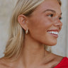 Model is shown from a side view. Model is wearing the Bette Croissant Hoops.