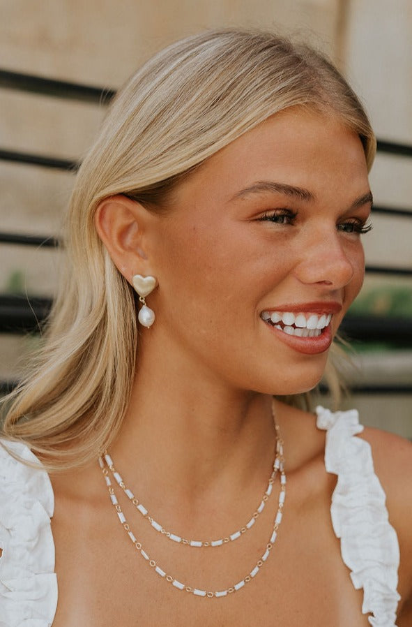 Side view of a model earing the Odessa Pearl Earrings.