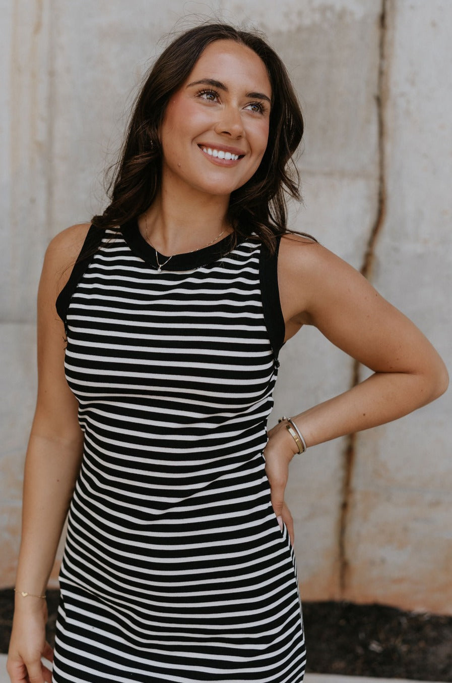 Fro\nt view of female model wearing the Andri Black & White Stripe Midi Dress which features Black and Cream Stripe Pattern, Midi Length, Slits On Each Side, Round Neckline and Sleeveless