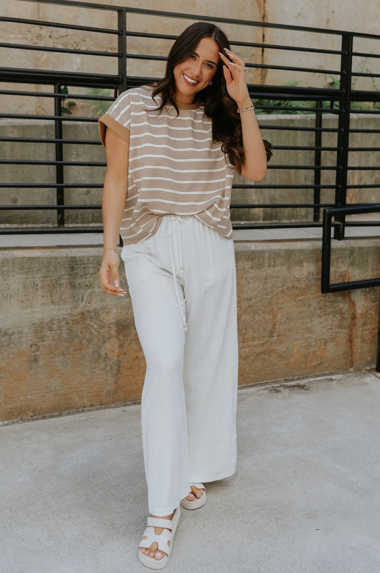 Full body view of female model wearing the Celeste Taupe & White Stripe Short Sleeve Top which features Taupe and Cream Lightweight Fabric, Thin Stripe Pattern, Round Neckline and Short Sleeves