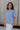 Side view of female model wearing the Ada Washed Cotton Short Sleeve Top which features Washed Cotton Fabric, Short Sleeves, Textured Thread Hem Details, Left Front Chest Pocket and Round Neckline