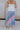Back view of female model wearing the Lily Aqua & Pink Multi Pleated Maxi Skirt which features Blue, Pink, Red, Purple and Aqua Floral Print, Satin Pleated Fabric, Maxi Length, Light Blue Lining and Side Zipper with Hook Closure